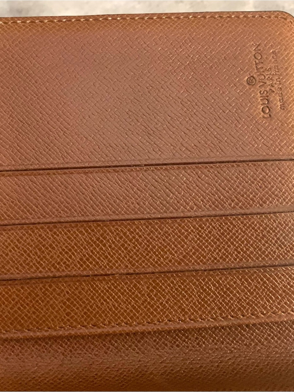 Louis Vuitton Brown Textured Leather bi fold wallet.